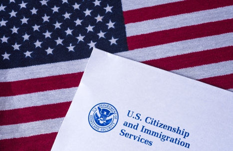 A U.S. Citizenship and Immigration Services form sitting on top of a United States flag.